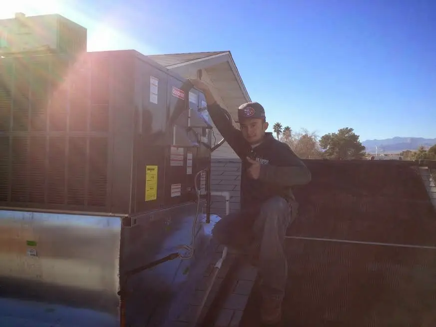 HVAC technician performing AC Tune-Up on a rooftop unit in West Carrollton